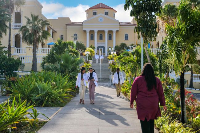 Students walk on campus grounds at American University of the Caribbean School of Medicine.